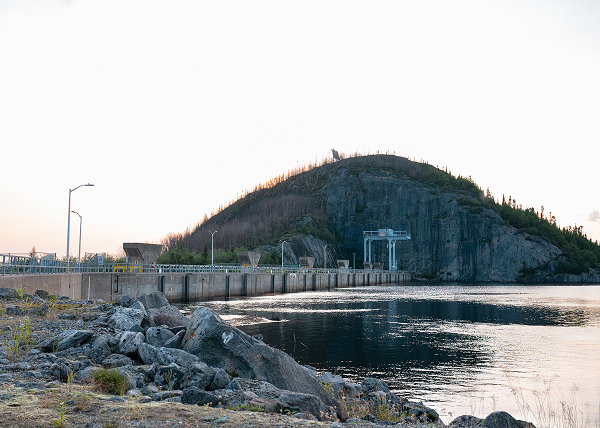 Hydroelectric dam and generating station beside a rocky shoreline